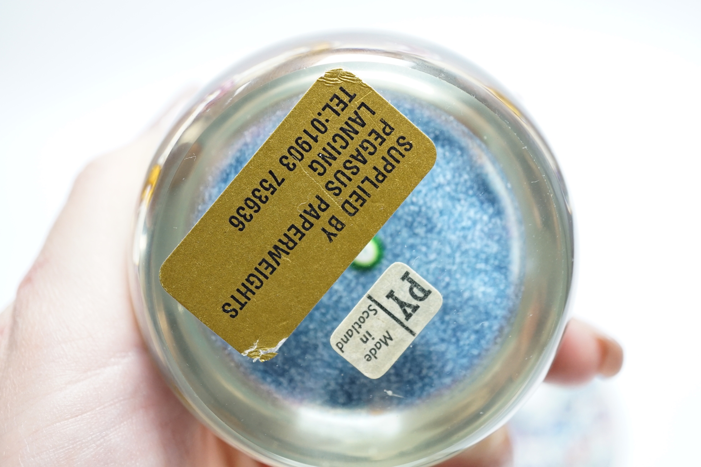 Two Paul Ysart glass paperweights, comprising a purple flower and latticino spoke on a blue jasper ground, ‘H’ cane, PY label, 7cm and ‘Harlequin’ glass paperweight, PY paper label, 8cm